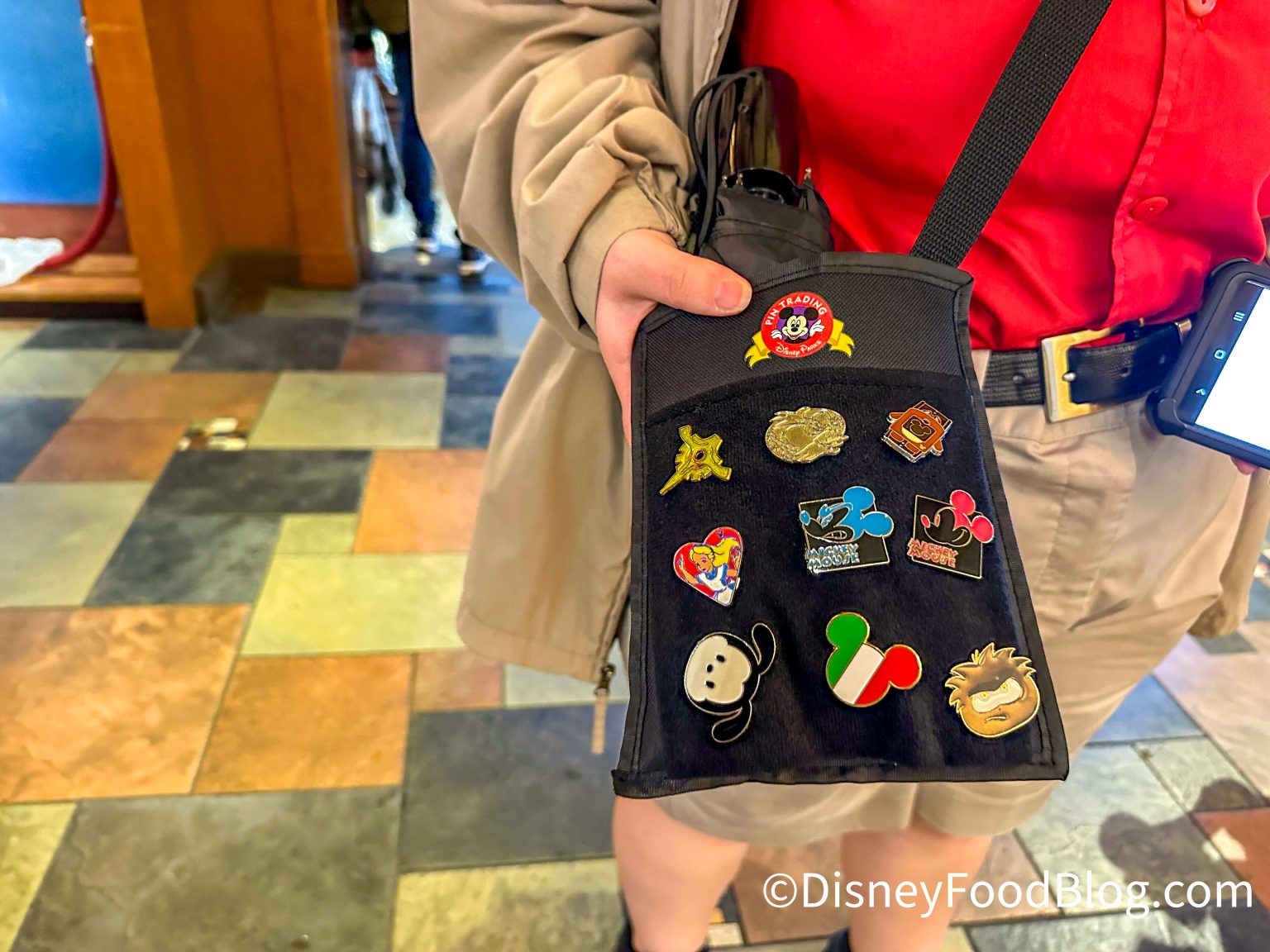 Cast member holding Disney pins for trading at World of Disney in Disney Springs