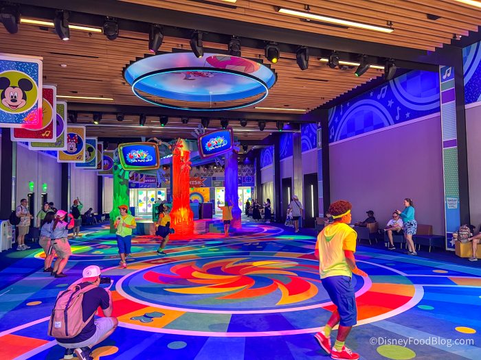 dark lighting with colorful. man in yellow shirt leads game